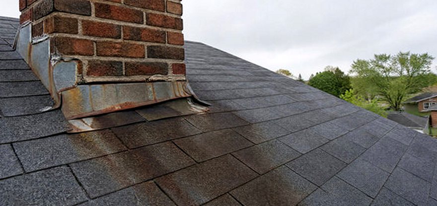Rusted chimney flashing bleeding stains down the shingles